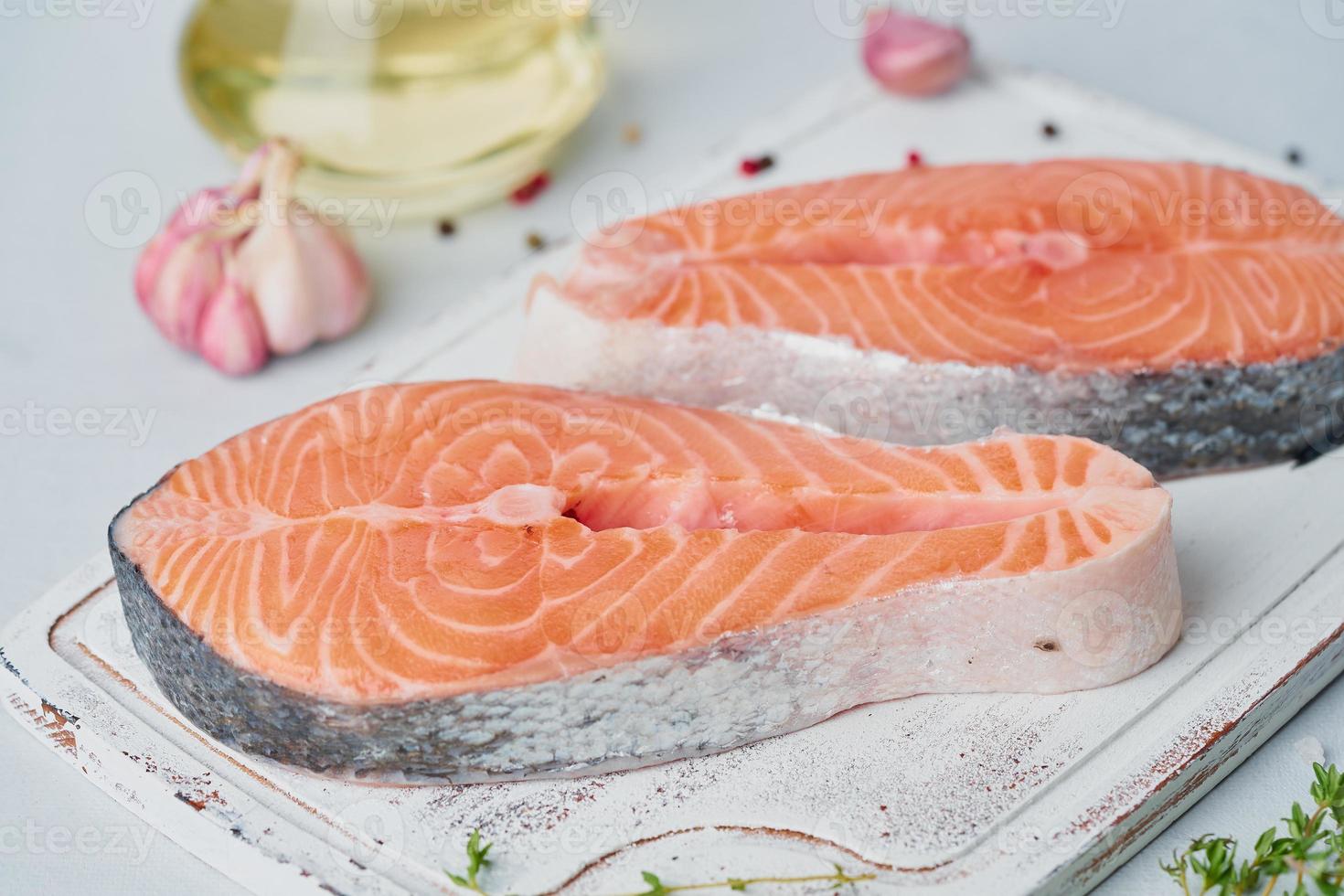 due bistecche di salmone, vista dall'alto, primo piano. filetto di pesce, affettati grandi su un tagliere foto