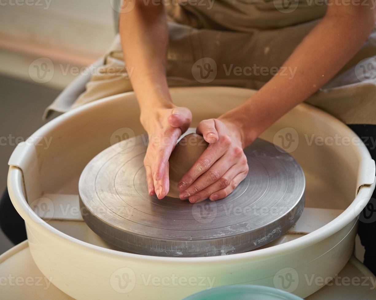 donna che fa ceramiche su ruota, creazione di articoli in ceramica. concetto per le piccole imprese foto