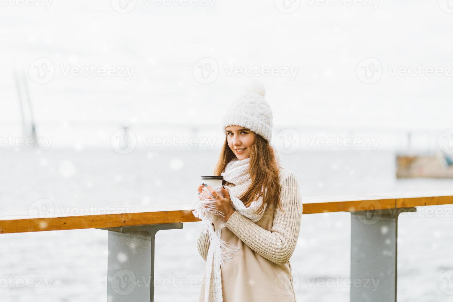 bella ragazza che beve caffè, tè da una tazza di plastica. inverno, vigilia di natale, capodanno. donna con i capelli lunghi sta andando in vacanza, stile scandinavo foto