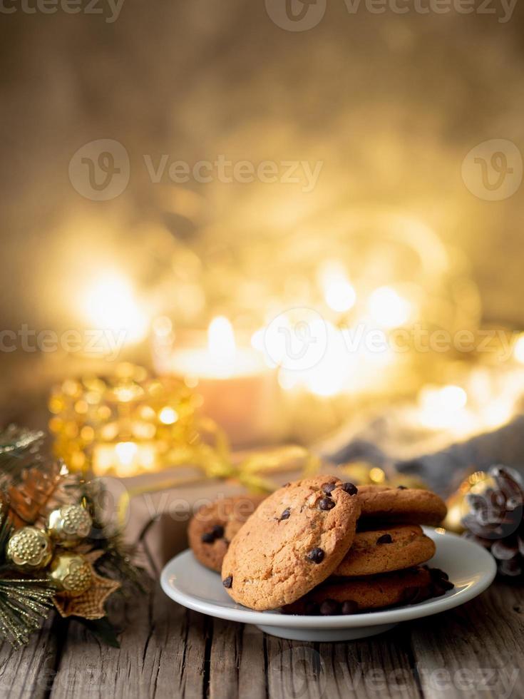 serata accogliente, tazza di bibita, decorazioni natalizie, candele e ghirlande di luci foto