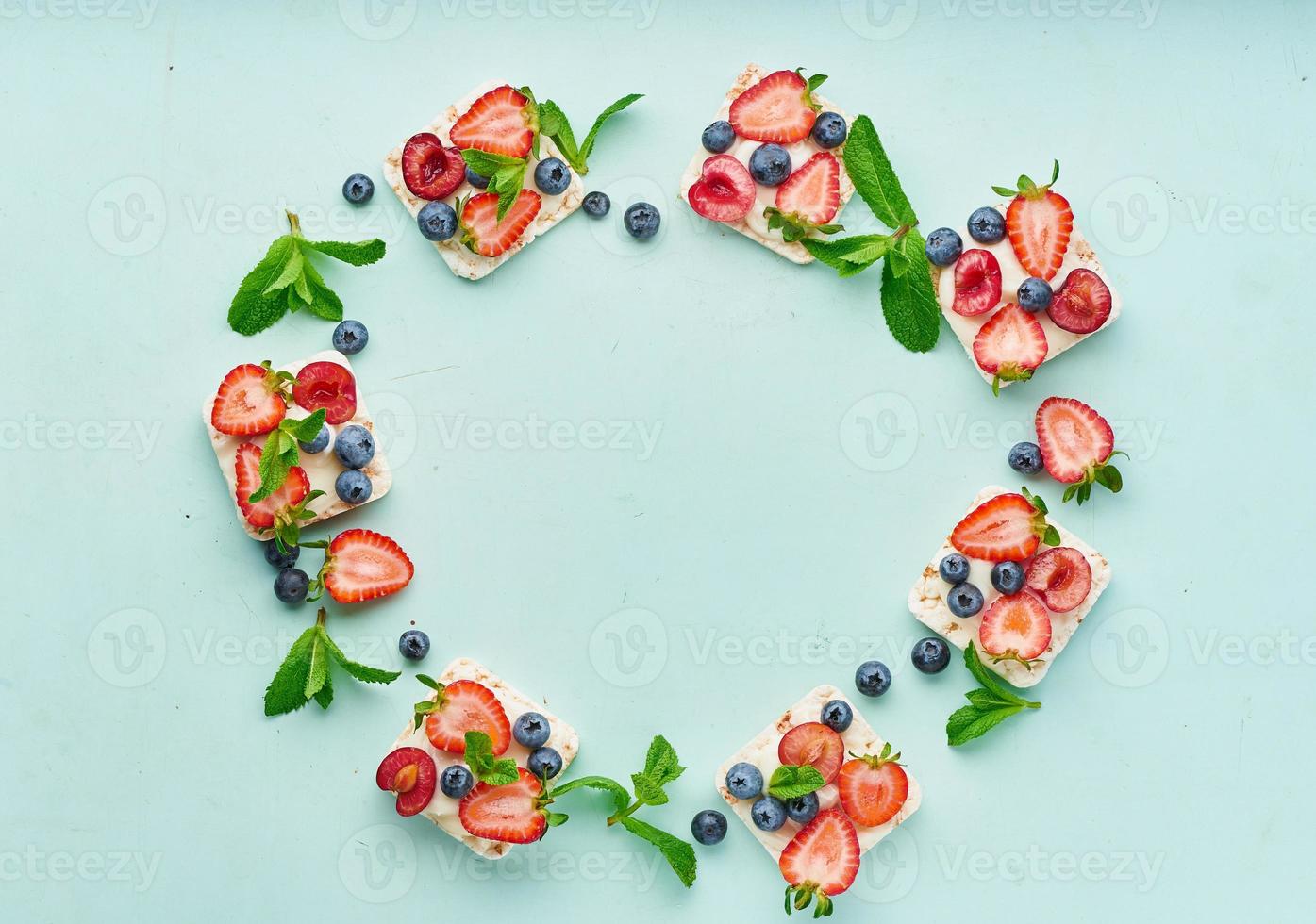 cornice di pane croccante con frutti di bosco e frutta concetto colorato su acquamarina turchese foto