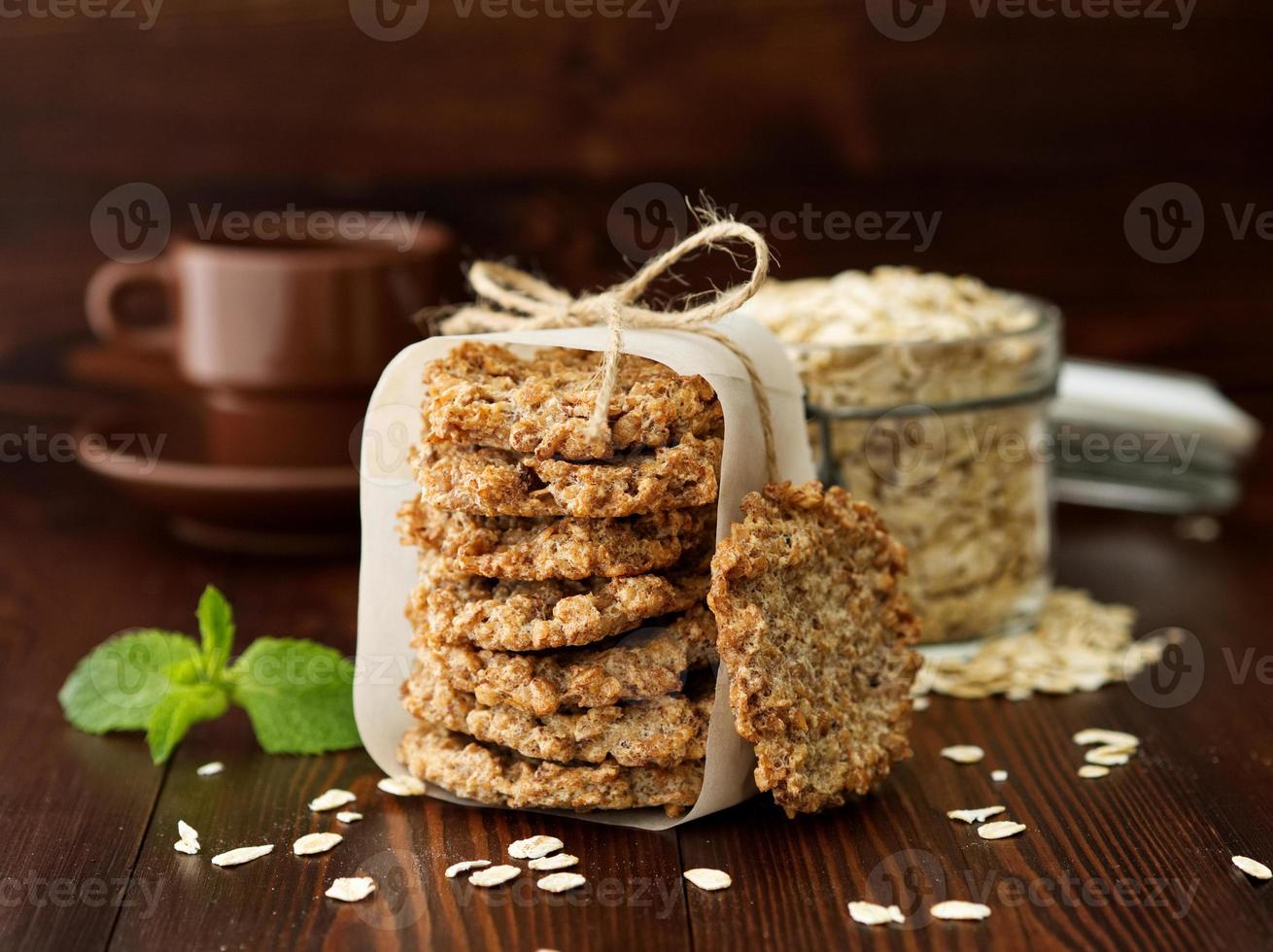 biscotti di farina d'avena fatti in casa con banana, avena, noci, uova e farina gratis su tavola di legno marrone scuro foto