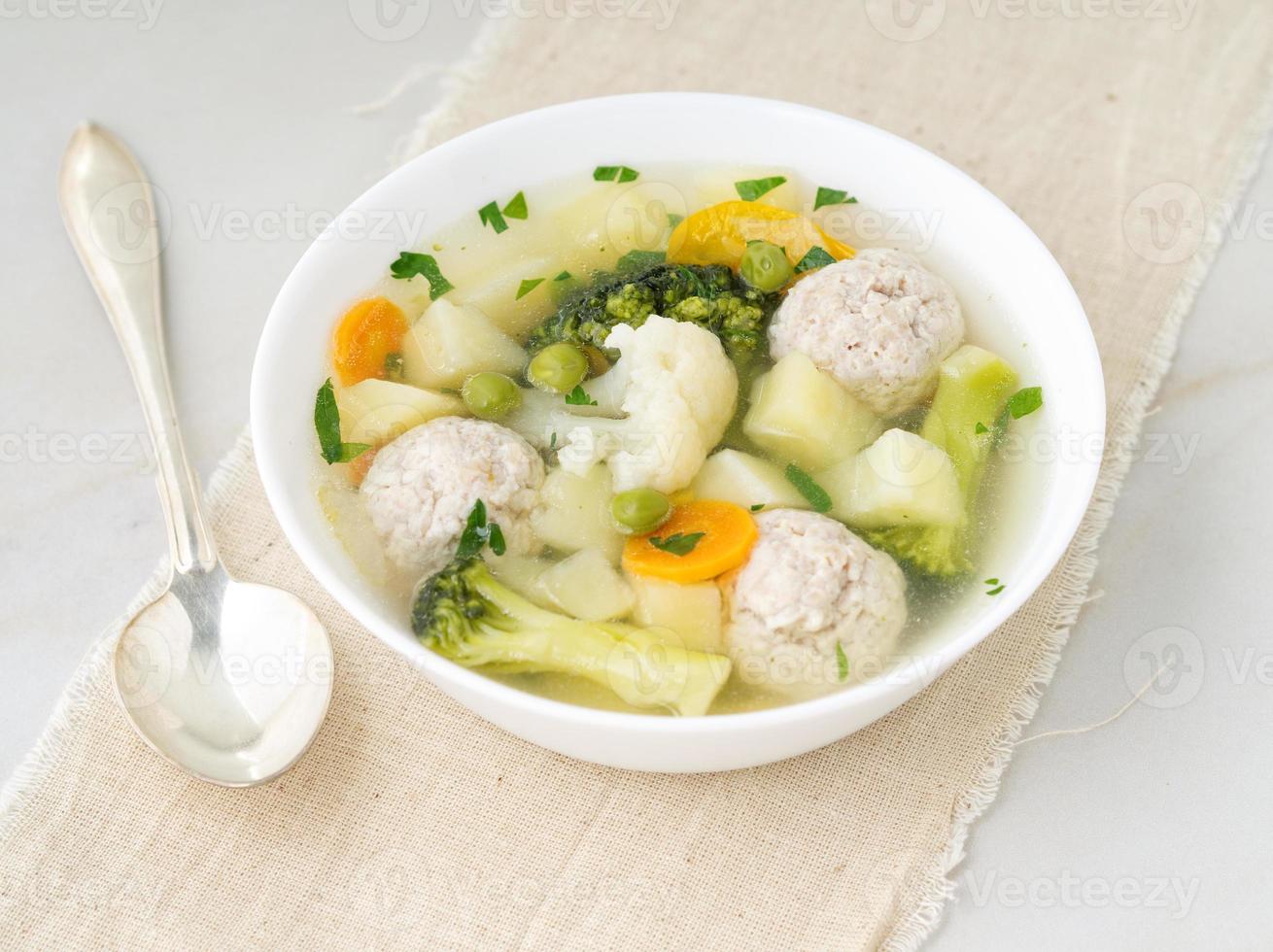 ciotola di zuppa, una tazza di brodo e verdure, polpette di tacchino e pollo, vista laterale foto