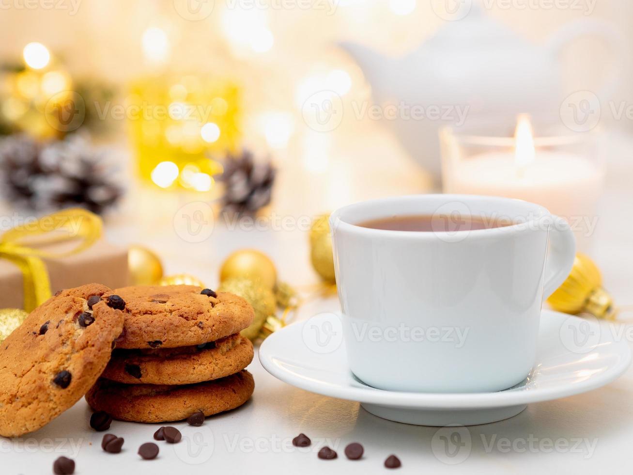 serata accogliente, tazza di bibita, decorazioni natalizie, candele e ghirlande di luci foto