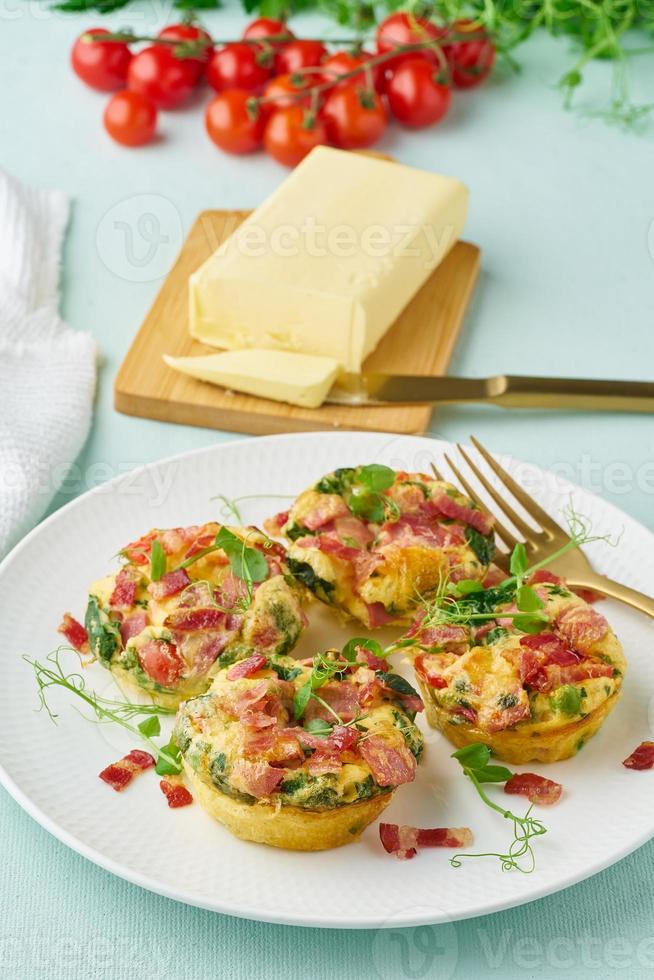 muffin all'uovo al forno con pancetta e pomodoro, dieta chetogenica, verticale di primo piano moderno pastello foto