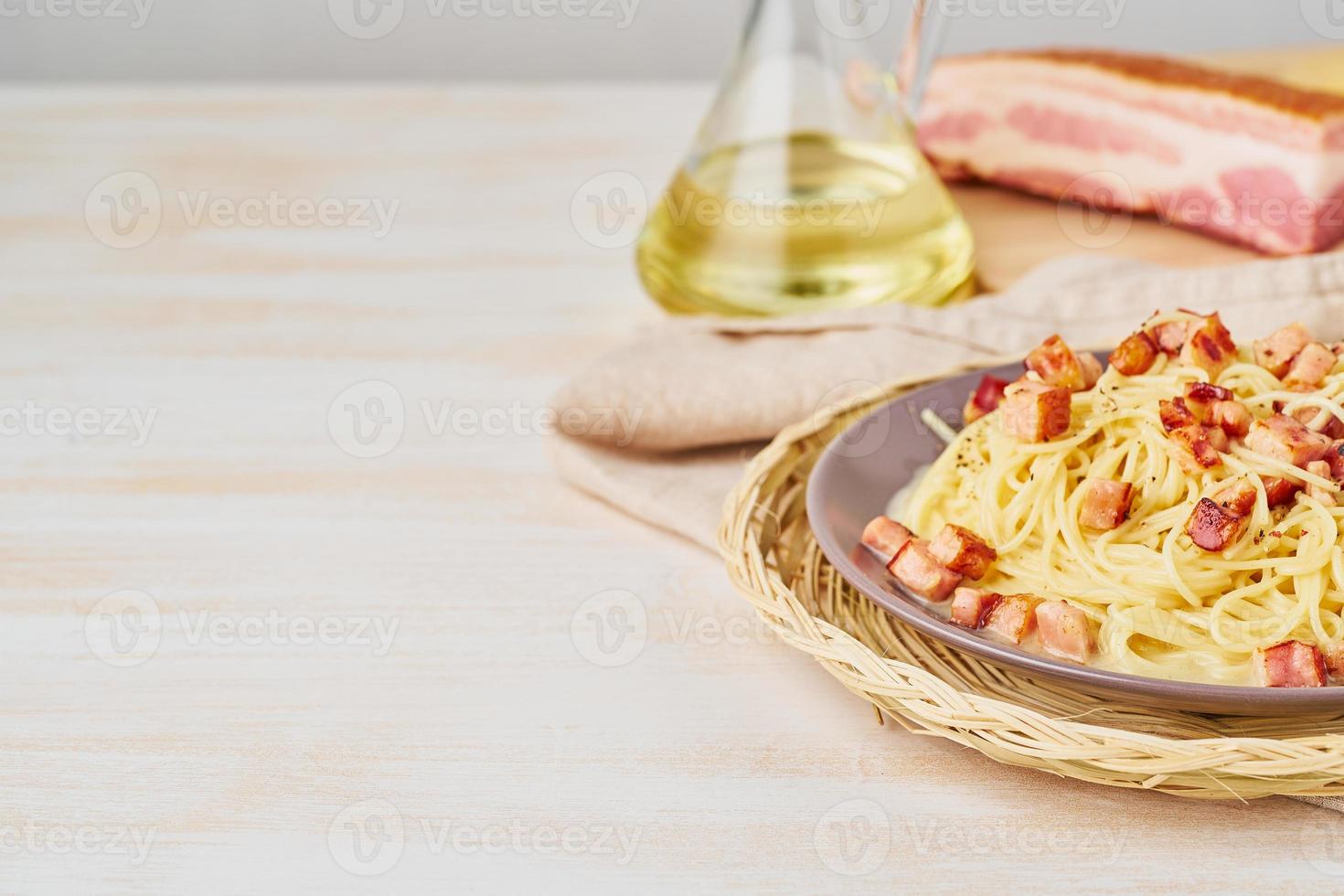 parte della pasta alla carbonara. spaghetti con pancetta, uovo, parmigiano e salsa di panna. vista laterale, copia spazio. cucina tradizionale italiana. foto