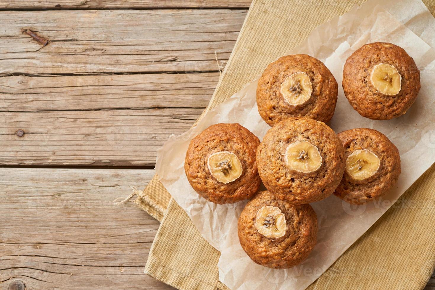 muffin alla banana, vista dall'alto, copia spazio. cupcakes sul vecchio tovagliolo di lino, tavola in legno rustico, una colazione con torta foto