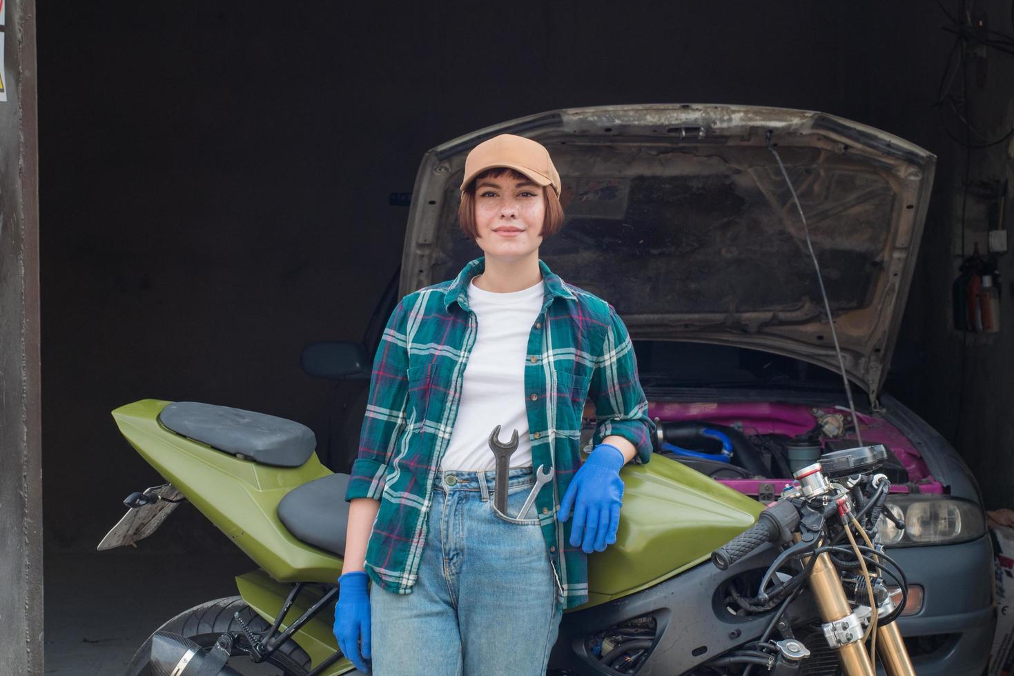 meccanico femminile che ripara l'auto in un garage foto