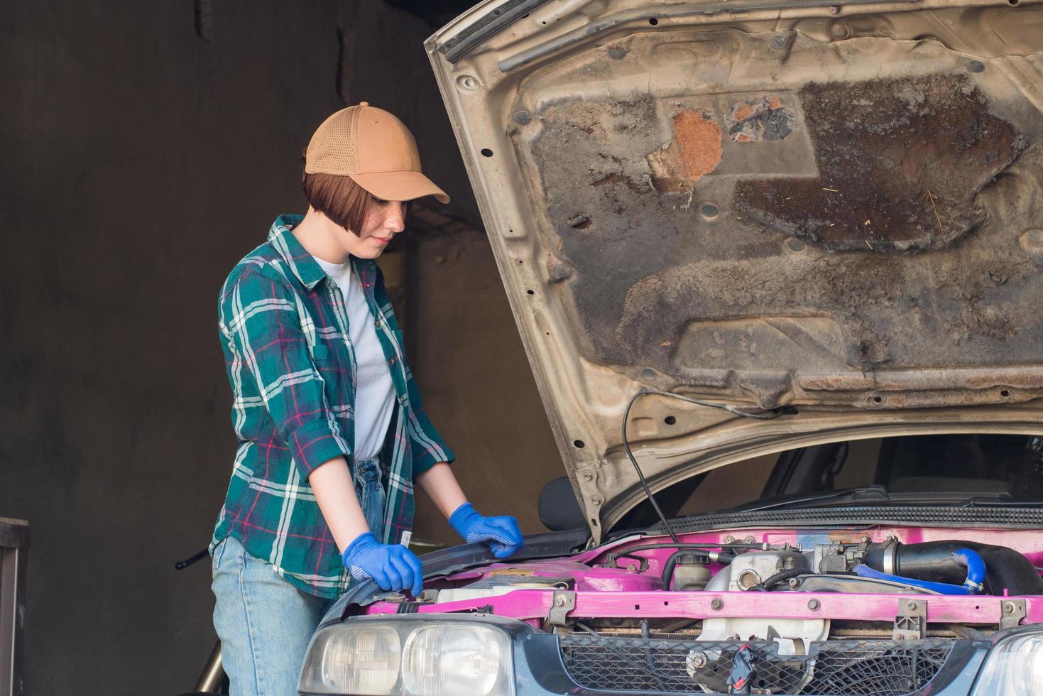 meccanico femminile che ripara l'auto in un garage foto