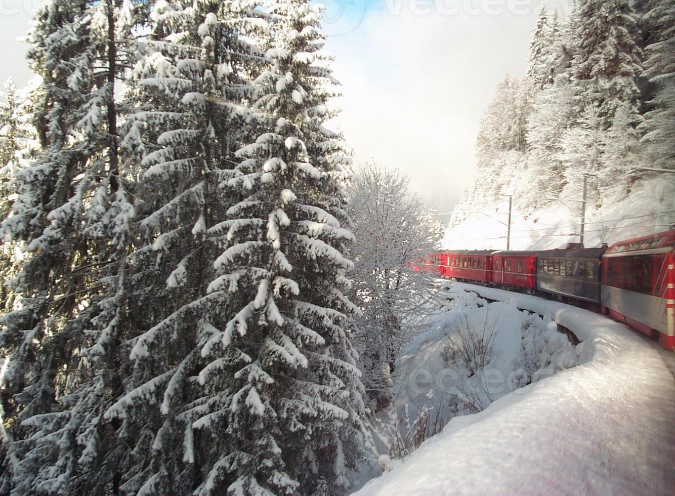 treno svizzero che viaggia attraverso le alpi in inverno foto