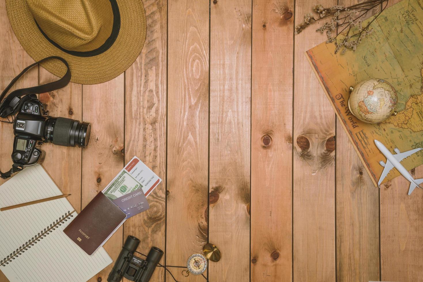 vista dall'alto degli accessori del viaggiatore articoli essenziali per le vacanze e oggetti diversi su sfondo di legno. sfondo del concetto di viaggio, prepararsi per il viaggio foto