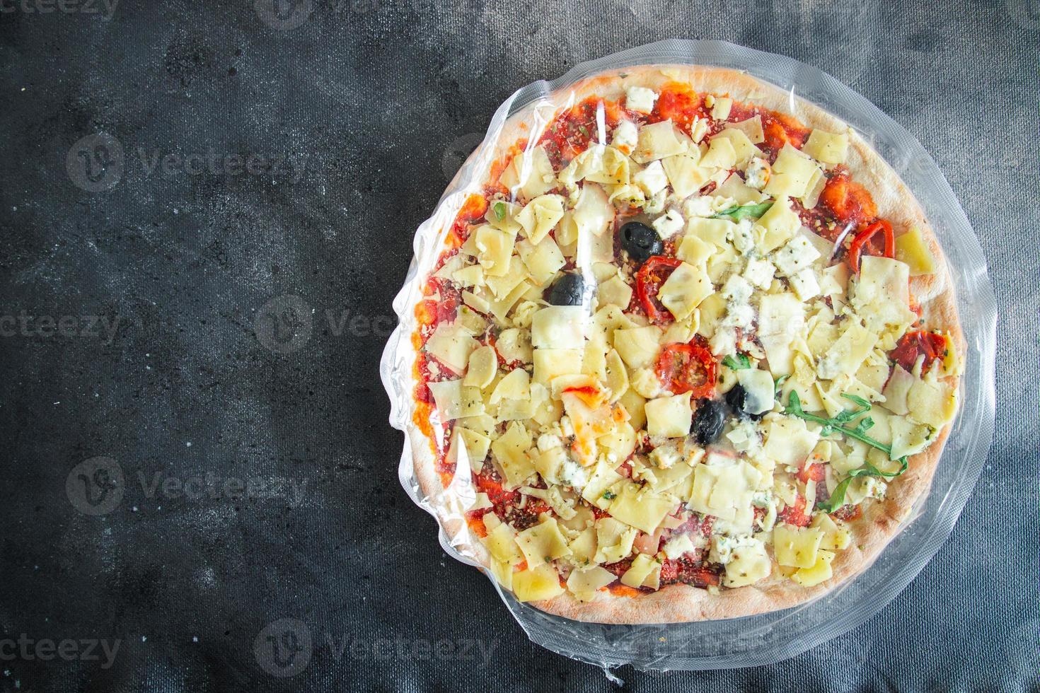 pizza congelata pellicola per imballaggio alimentare cellophane scongelare pasti freschi snack sul tavolo spazio di copia foto