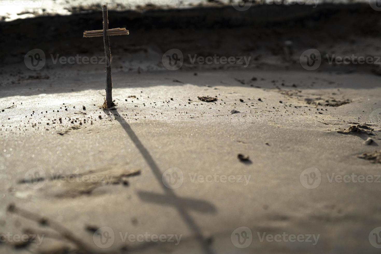 una croce cristiana in piedi da sola nella sabbia foto