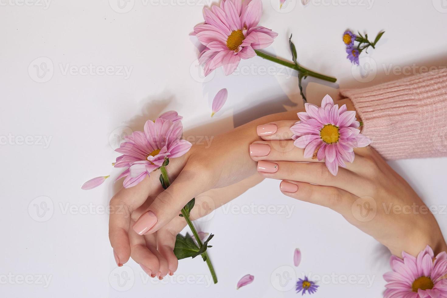 moda arte cura della pelle delle mani e fiori rosa nelle mani delle donne foto