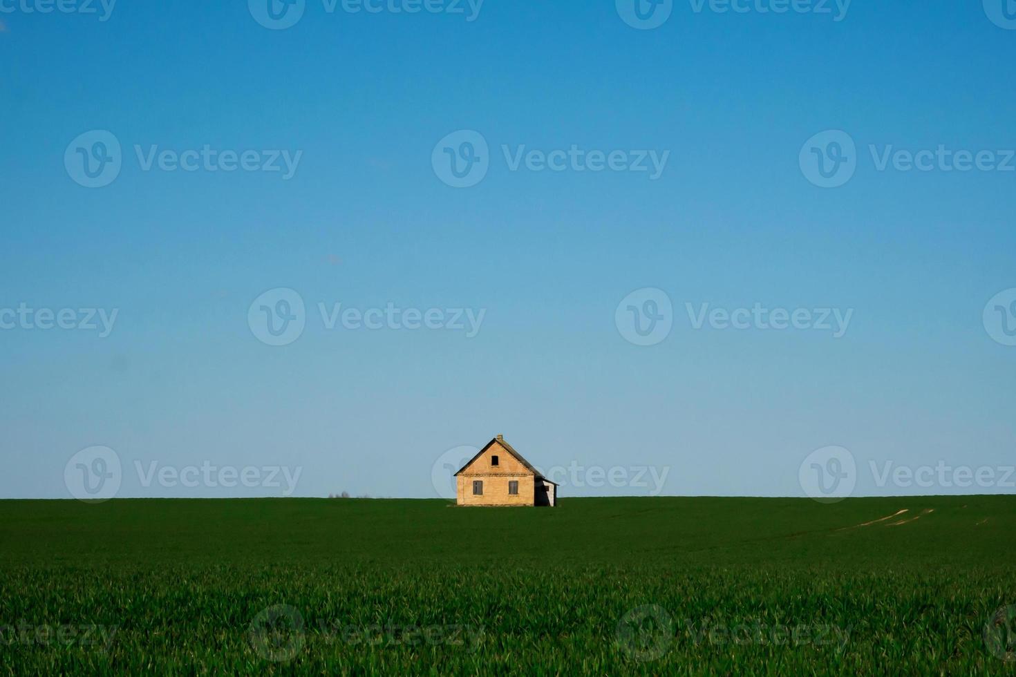 casa su un campo verde e cielo blu foto