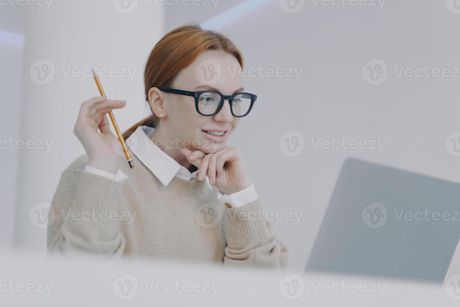 studentessa sta leggendo sul pc. la ragazza sorridente sta sfogliando le informazioni e facendo ricerche. foto