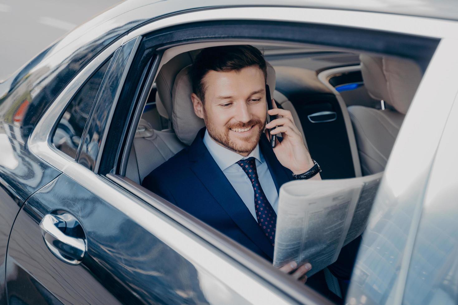 elegante uomo d'affari in abiti eleganti e formali che viaggiano in auto di lusso foto