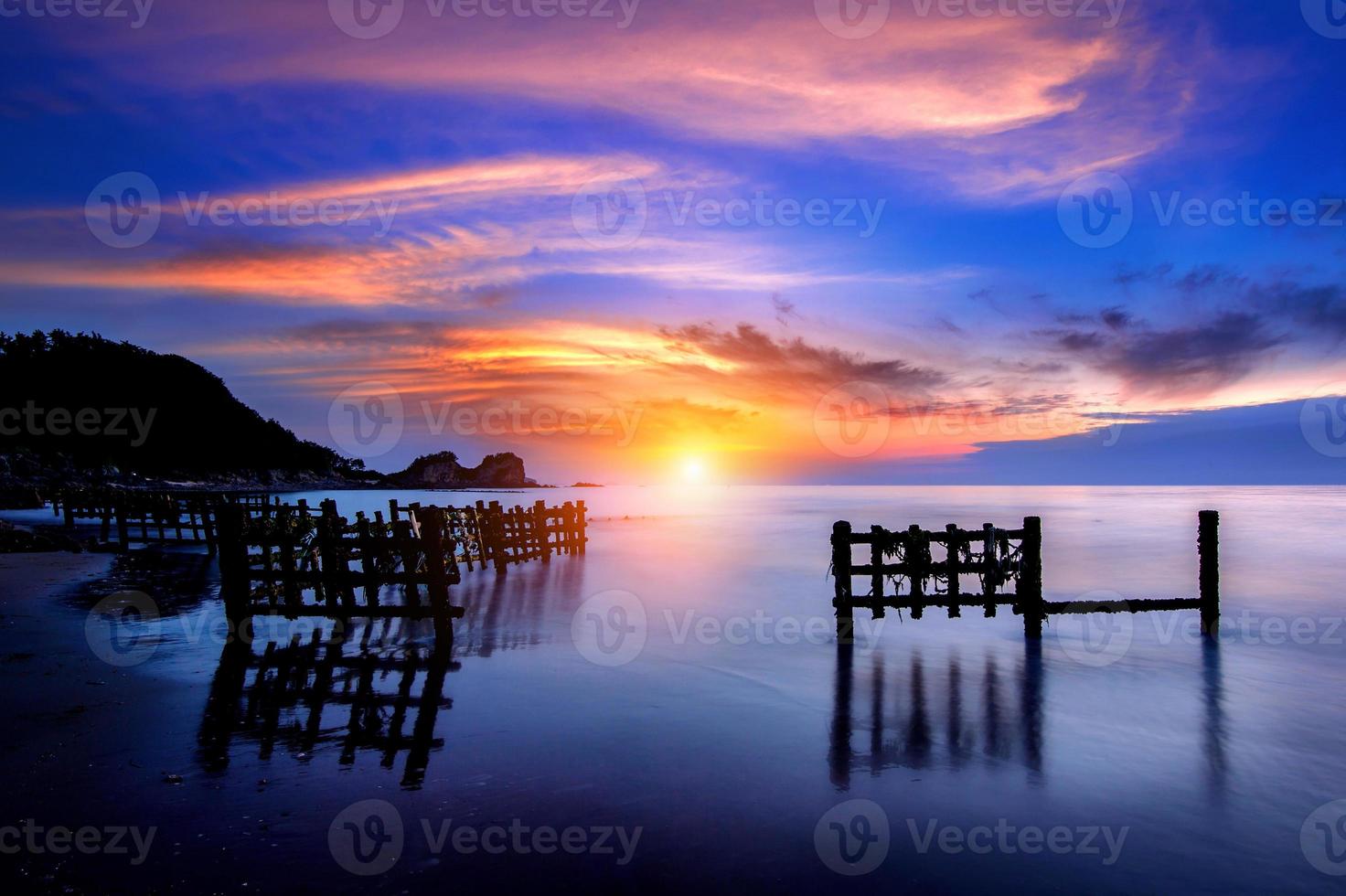 vista sul mare con fila di legno al tramonto foto