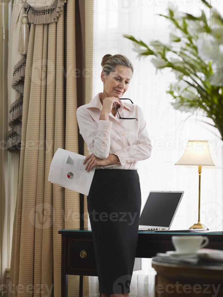 donna di affari premurosa con documento in ufficio a casa foto