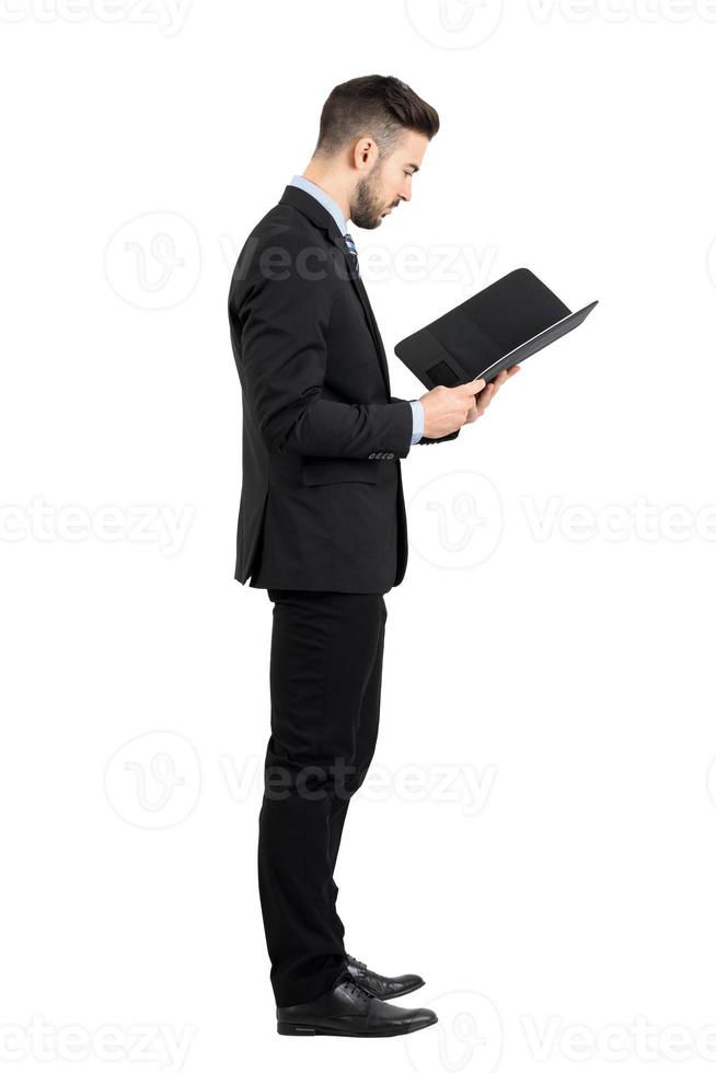 uomo d'affari in tuta lettura documento o contratto vista laterale. foto