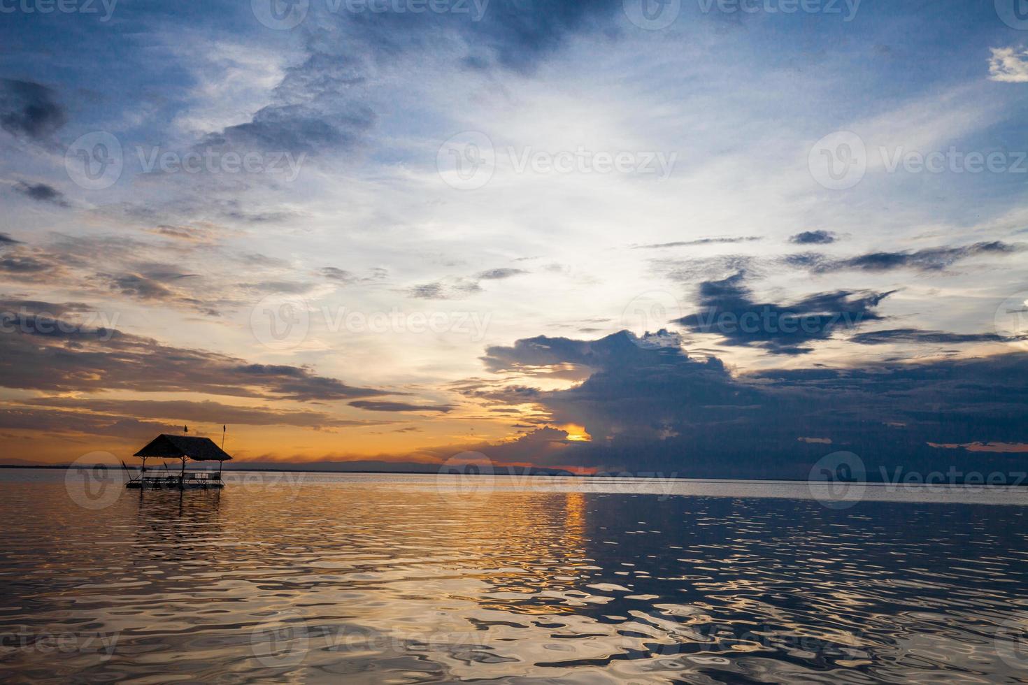 pontone che galleggia nell'acqua al tramonto foto