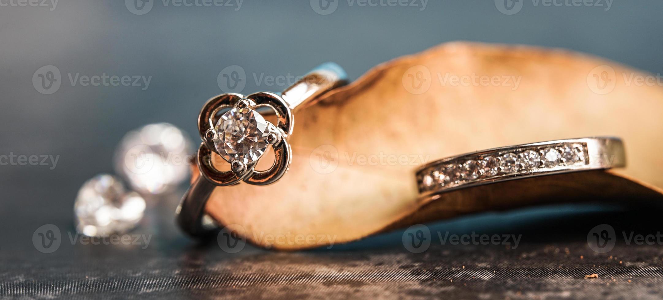 primo piano di un anello di fidanzamento con diamante posto su una foglia. concetto di amore e matrimonio. foto