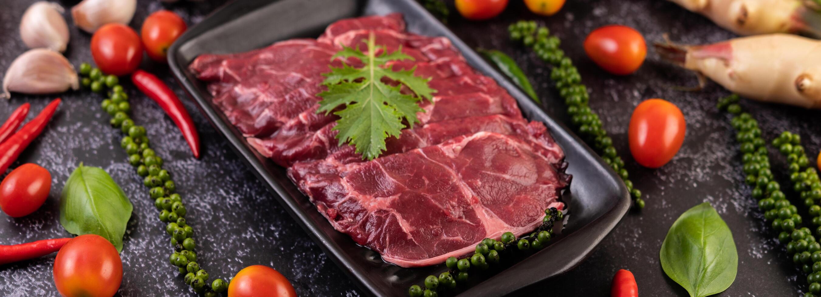 carne di maiale usata per cucinare con peperoncino, pomodoro, basilico e semi di peperone fresco. foto