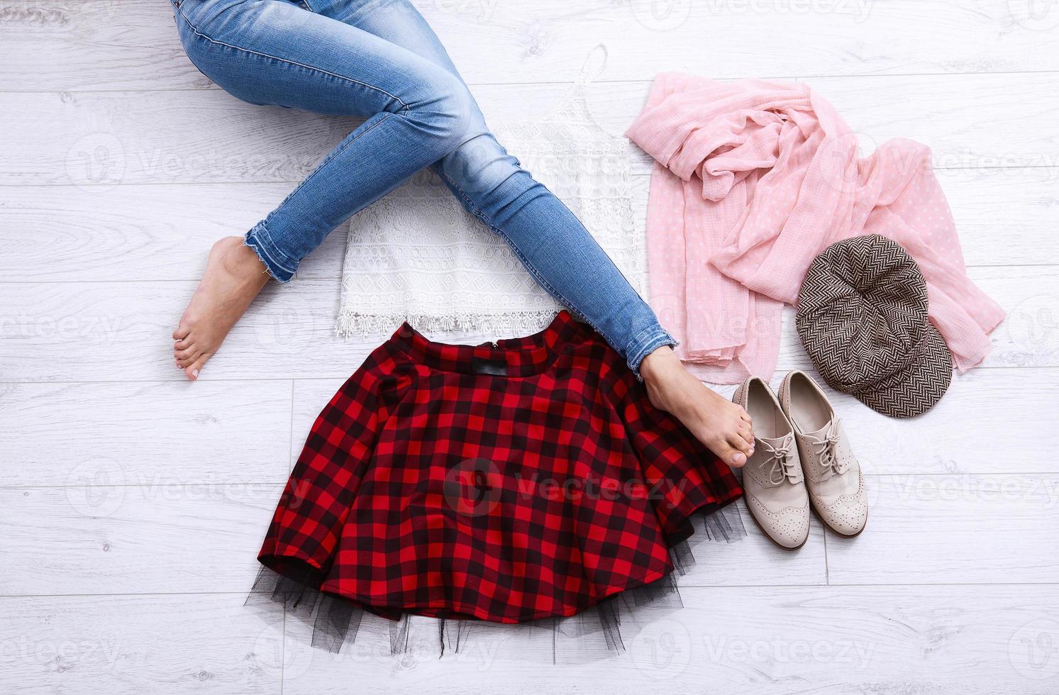 vestito elegante con accessori e gambe femminili su fondo di legno bianco. vista dall'alto e spazio di copia foto