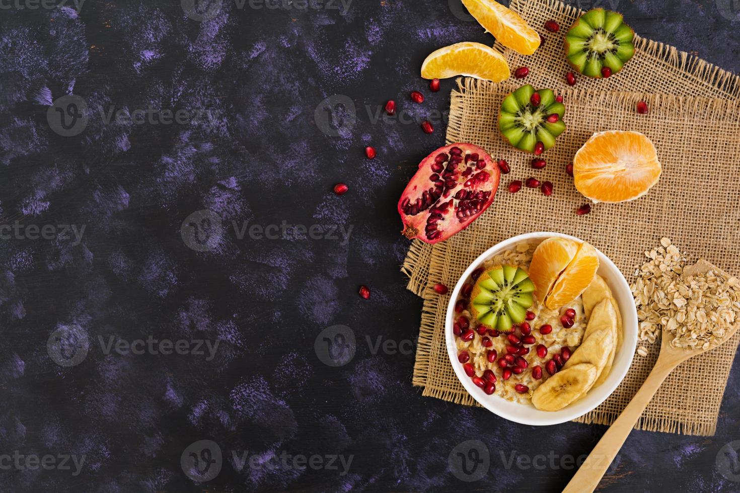 colazione salutare. farina d'avena con frutta su sfondo scuro. vista dall'alto foto