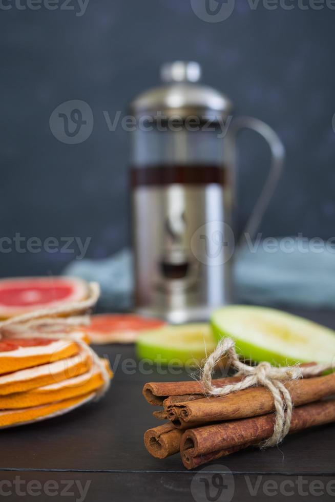 tè alla frutta con mela, pompelmo e cannella su fondo di legno foto