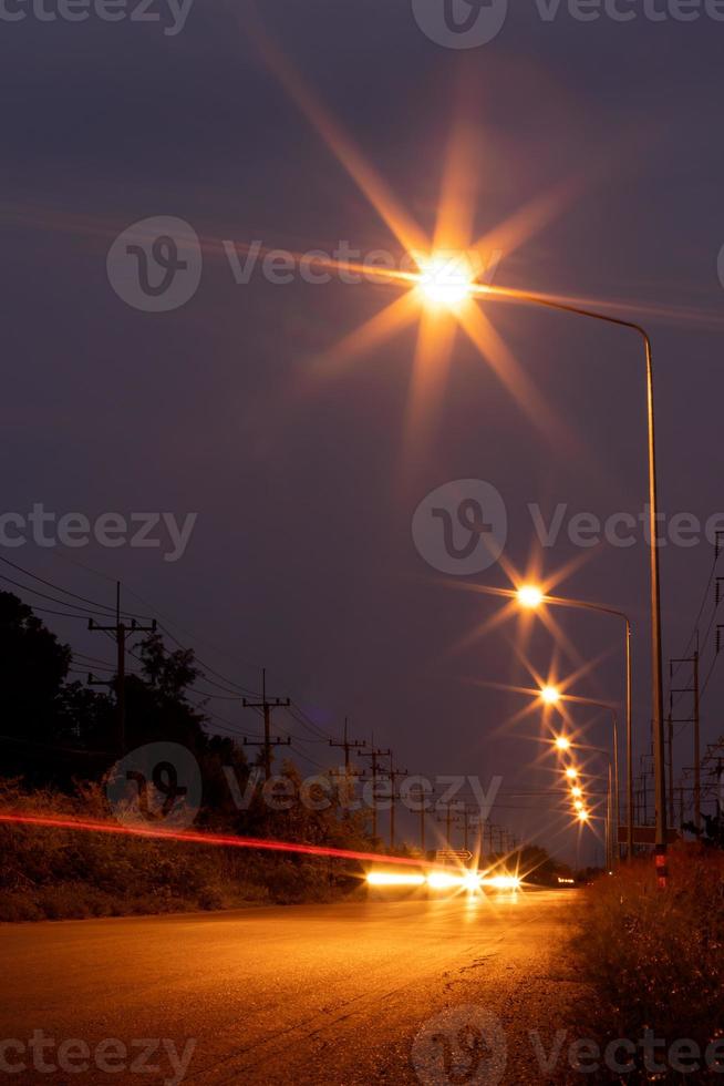 accendere la lampada con i fari sulla strada al buio. foto