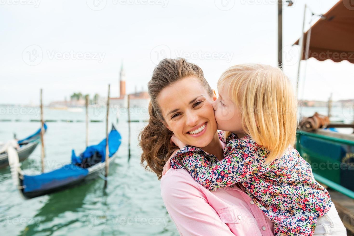 bambino che bacia madre felice a venezia foto