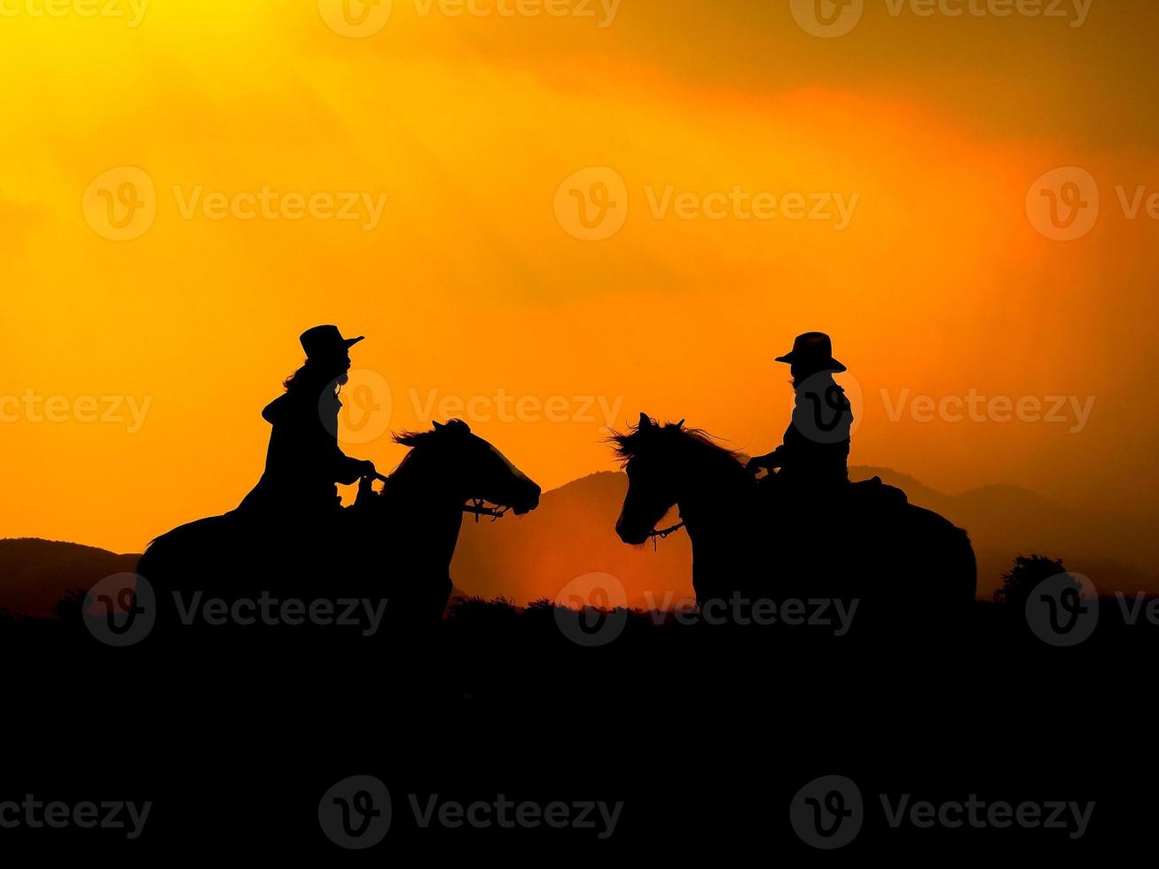 il cowboy occidentale ha costretto i suoi cavalli a fermarsi mentre il sole stava tramontando, in terre dove la legge non è ancora arrivata foto