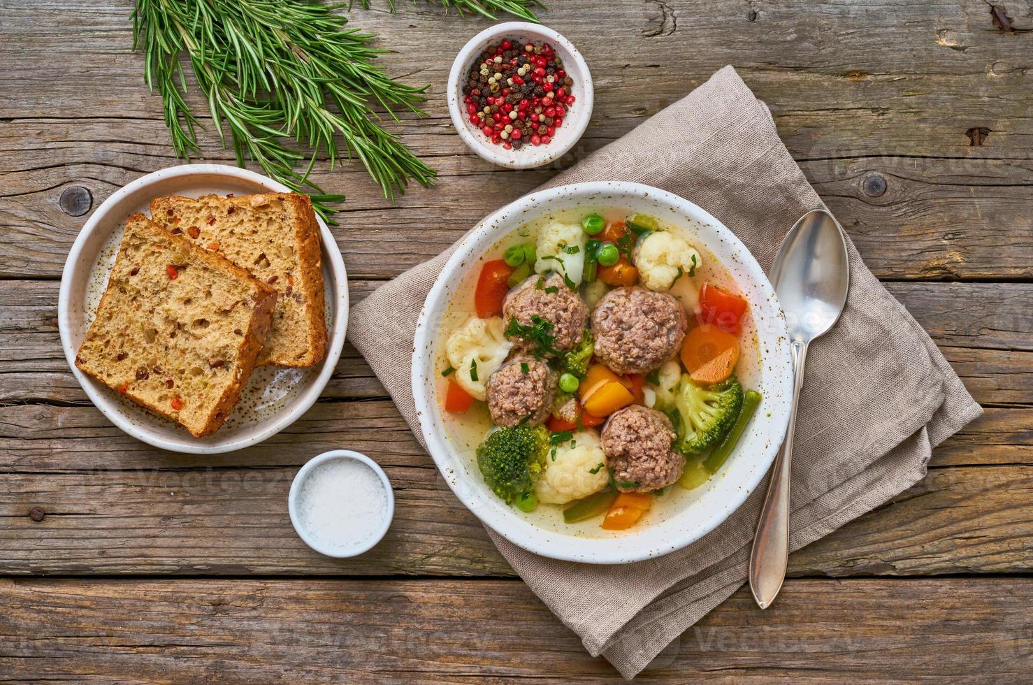 zuppa di polpette in piatto bianco sul vecchio tavolo grigio rustico in legno, vista dall'alto foto