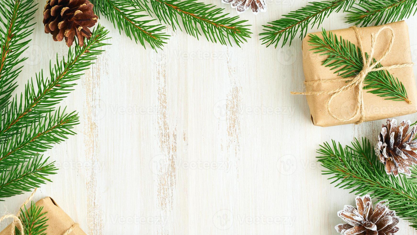 natale e felice anno nuovo sfondo in legno a zero rifiuti. regalo fatto a mano scatola di Natale, rami di abete, carta artigianale, vista dall'alto, spazio per la copia. concetto ecologico senza plastica foto