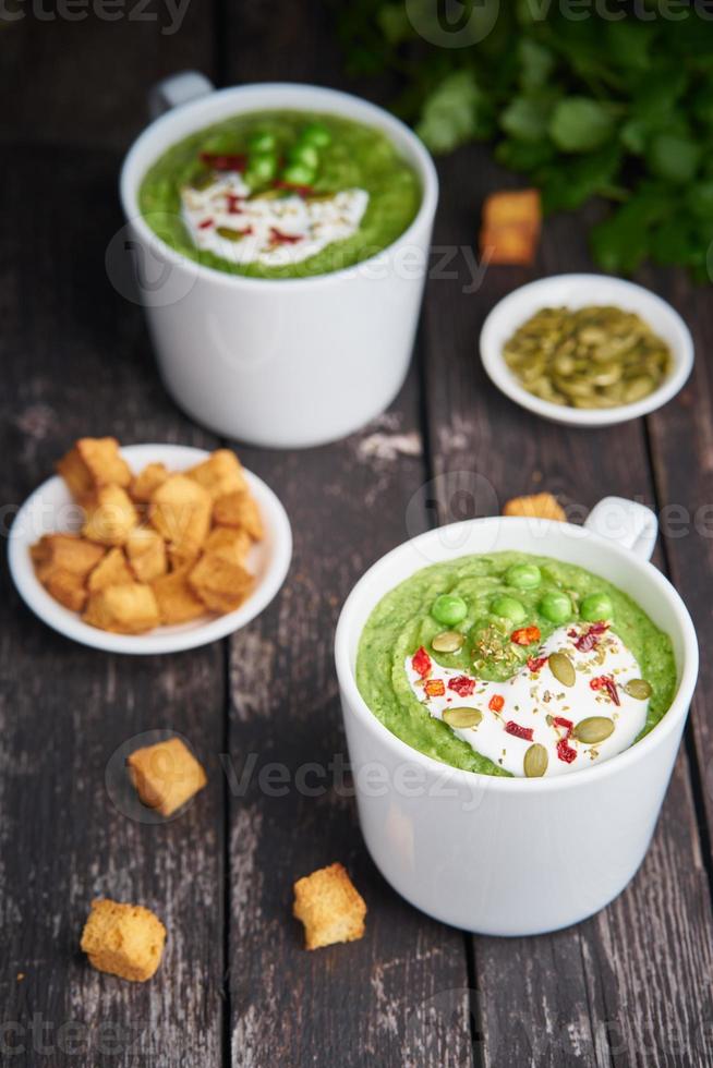 dieta vegana zuppa di broccoli, zucchine, piselli su fondo di legno scuro foto