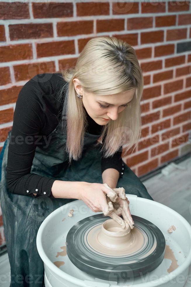 donna che fa ceramica sulla ruota, primo piano delle mani. concetto per donna in freelance, affari, hobby. guadagnare soldi extra, trasformare gli hobby in denaro, trasformare la passione in lavoro foto