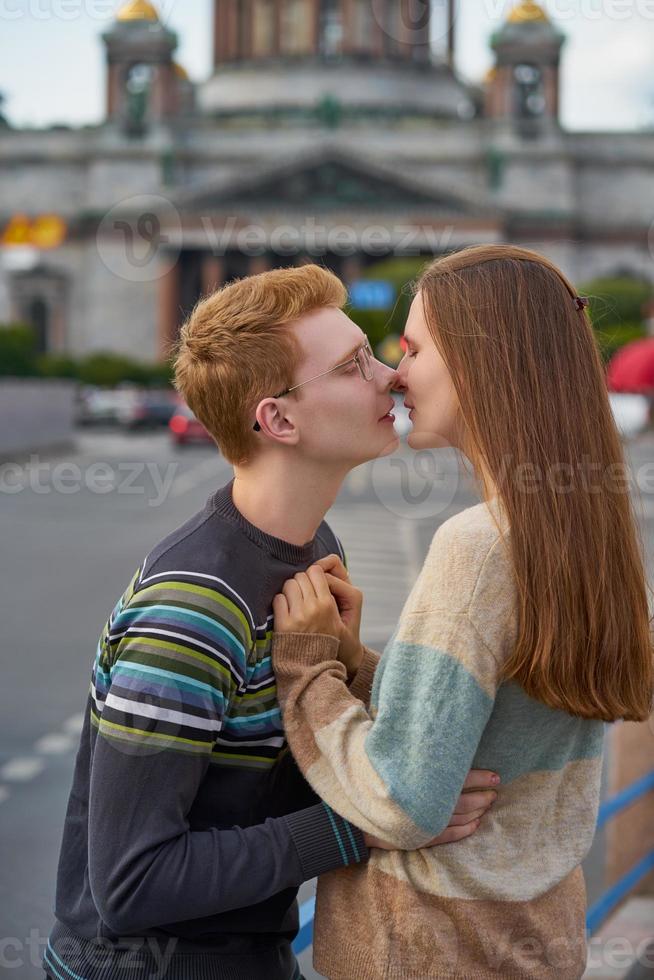 il ragazzo guarda teneramente la ragazza e vuole baciarla. concetto di amore adolescenziale e primo bacio foto