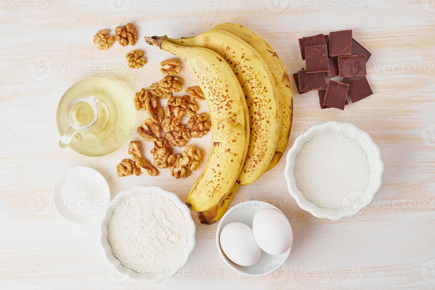 ingredienti per il pane alla banana. ricetta passo passo banana, noci, cioccolato, farina, uova, olio, zucchero foto