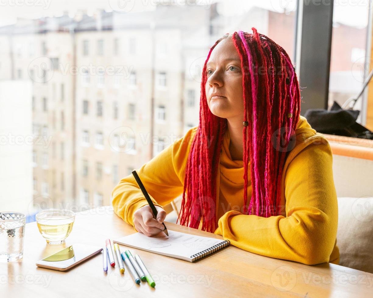 concetto di nomade digitale. ragazza freelance che lavora a distanza sul laptop in un bar, coworking. foto