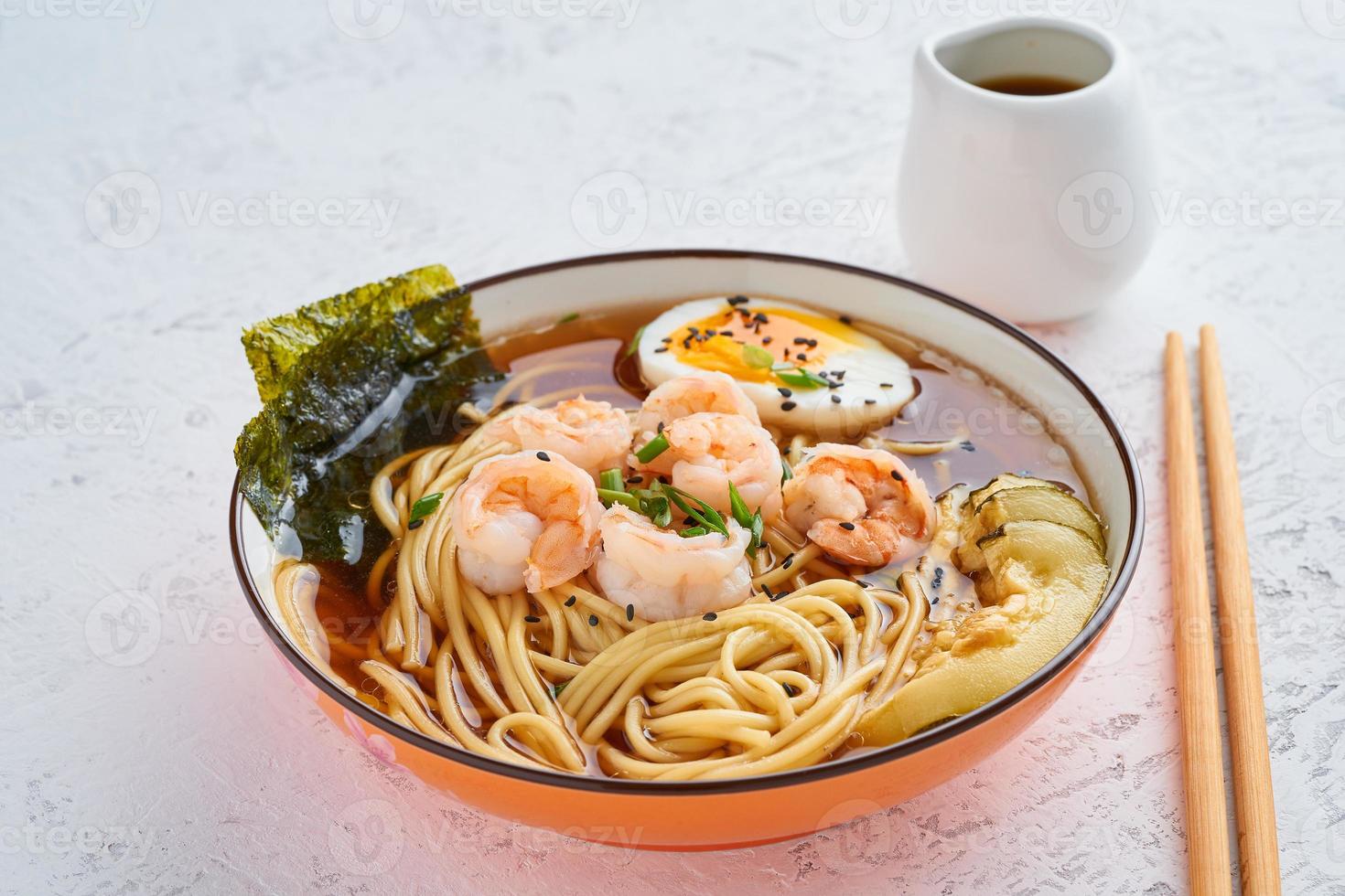 zuppa asiatica con noodles, ramen con gamberi, pasta di miso, salsa di soia. tavolo in pietra bianca, vista laterale foto