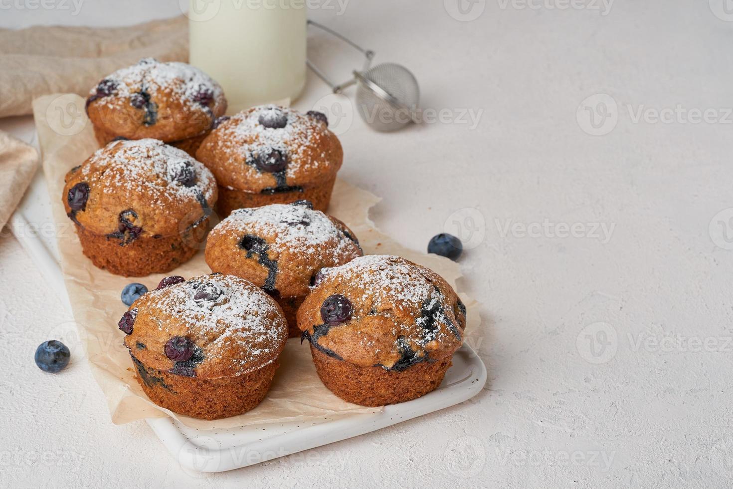 muffin ai mirtilli, vista laterale, copia spazio. cupcakes con frutti di bosco sul tavolo di cemento bianco foto