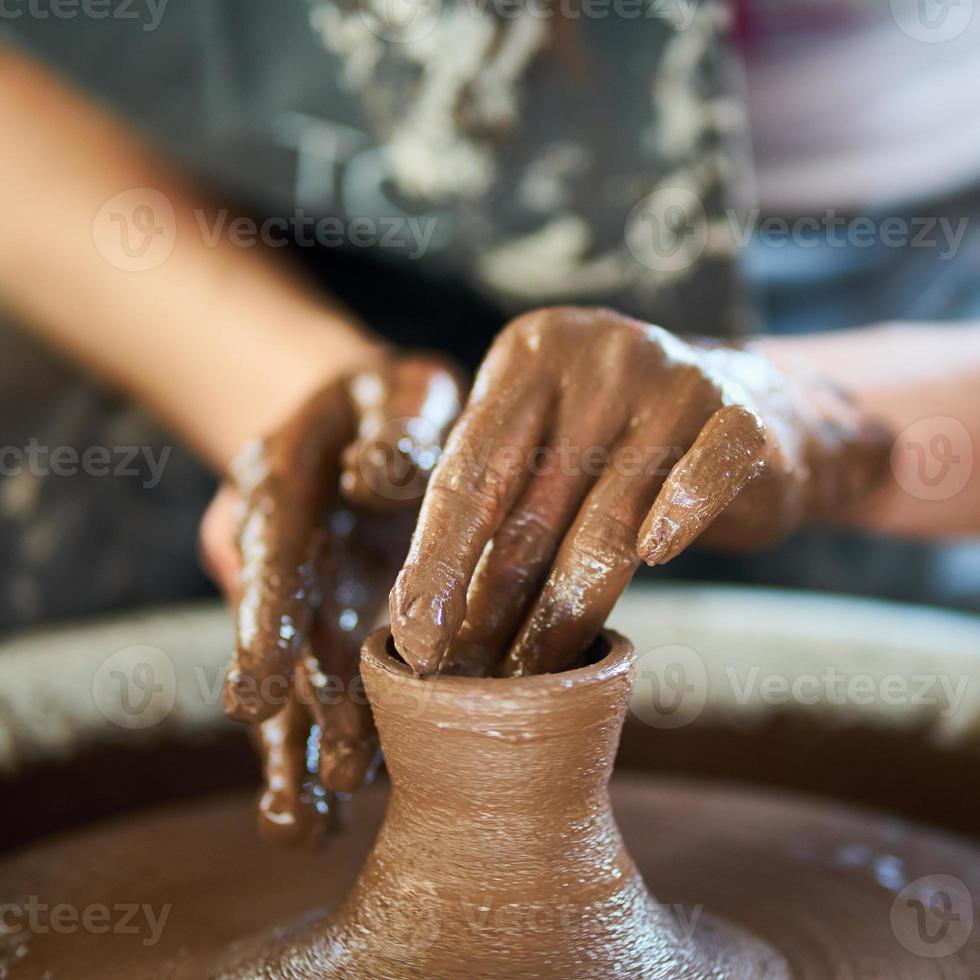 donna che fa ceramiche su ruota, primo piano delle mani, creazione di articoli in ceramica. foto
