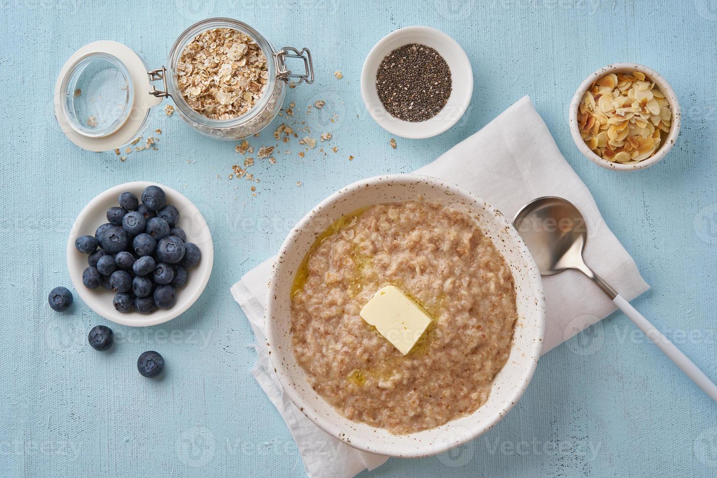 farina d'avena con burro e condimenti. mirtilli, semi di chia, scaglie di mandorle. vista dall'alto foto