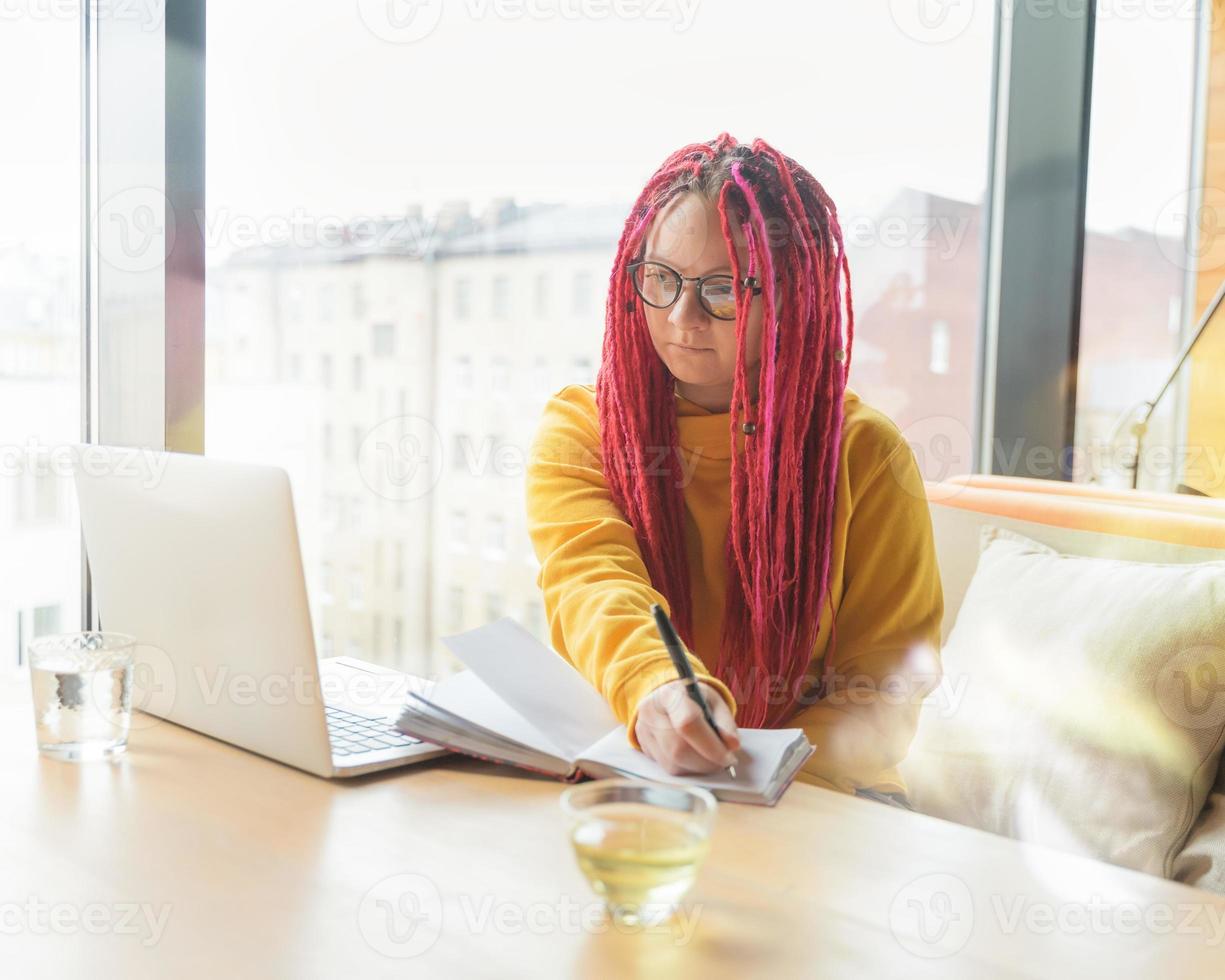 concetto di nomade digitale. ragazza freelance che lavora a distanza sul laptop in un bar, coworking. foto