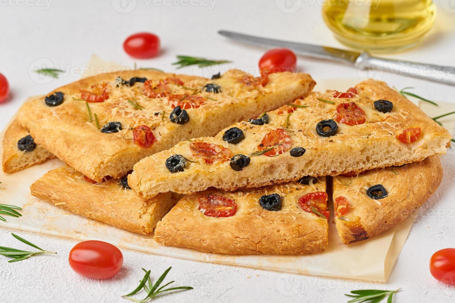 focaccia, pizza, focaccia italiana a fette con pomodori, olive e rosmarino foto