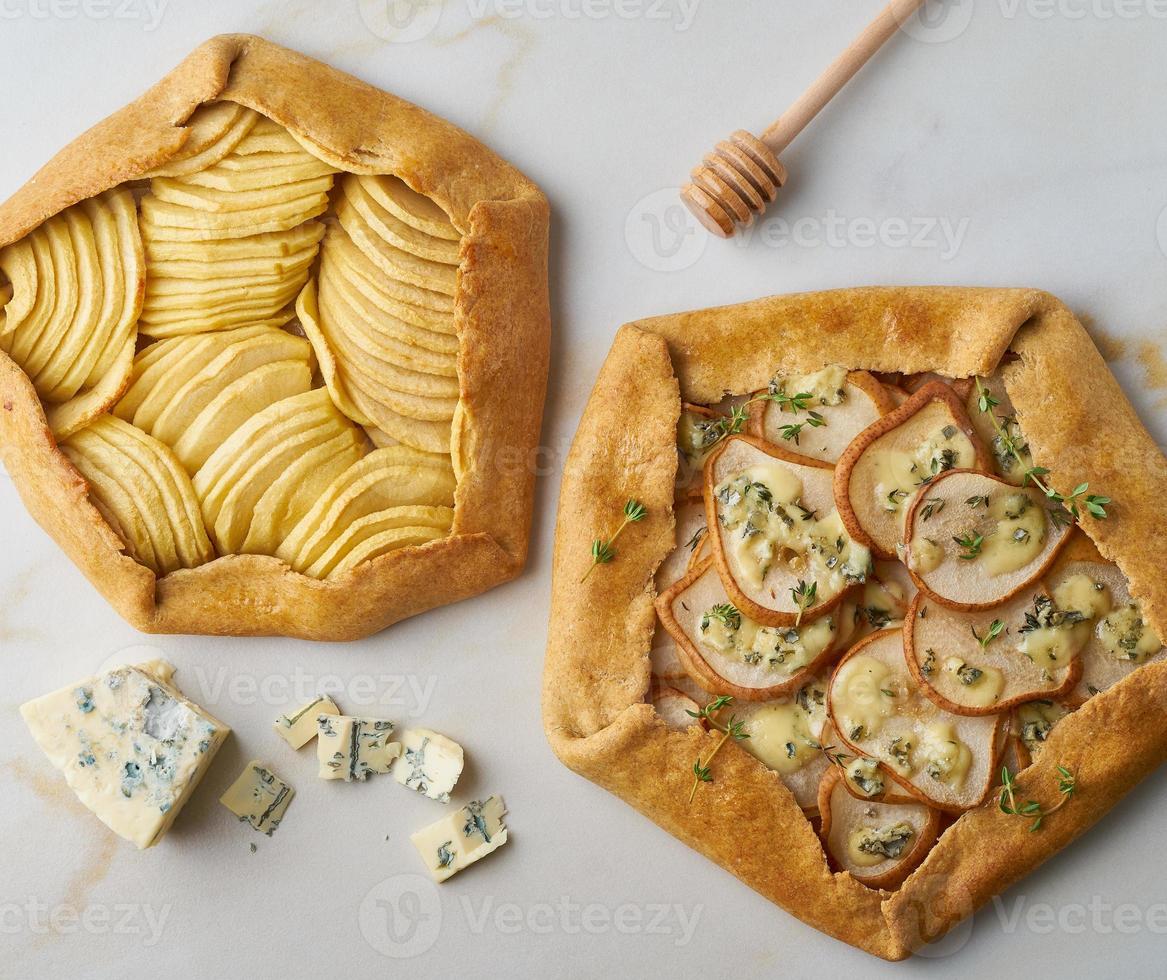 galette di frutta, torta di mele con miele, torta salata di pere e formaggio, tavolo in marmo, vista dall'alto foto