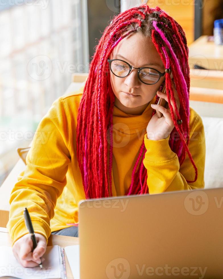 concetto di nomade digitale. ragazza freelance che lavora a distanza sul laptop in un bar, coworking. foto