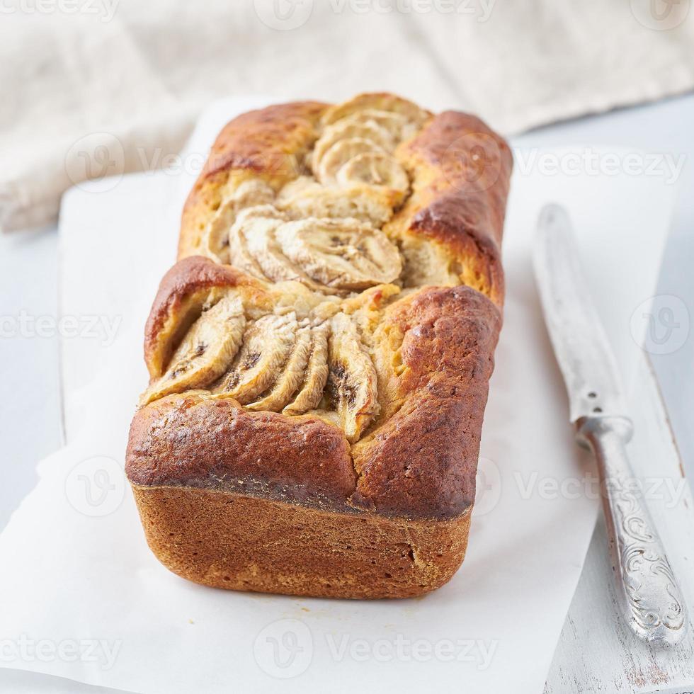 pane alla banana, torta con banana. la colazione del mattino su sfondo grigio chiaro foto