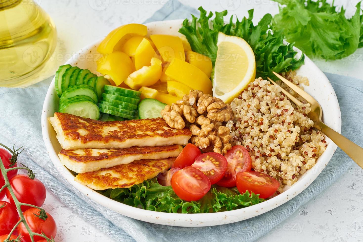 ciotola di buddha con halloumi, quinoa, insalata di lattuga, cibo vegetariano, sfondo bianco, vista dall'alto foto